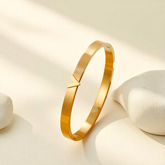 Gold bracelet on a light beige background