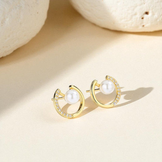 Gold hoop earrings with pearls on a beige background Orlaya Jewellery