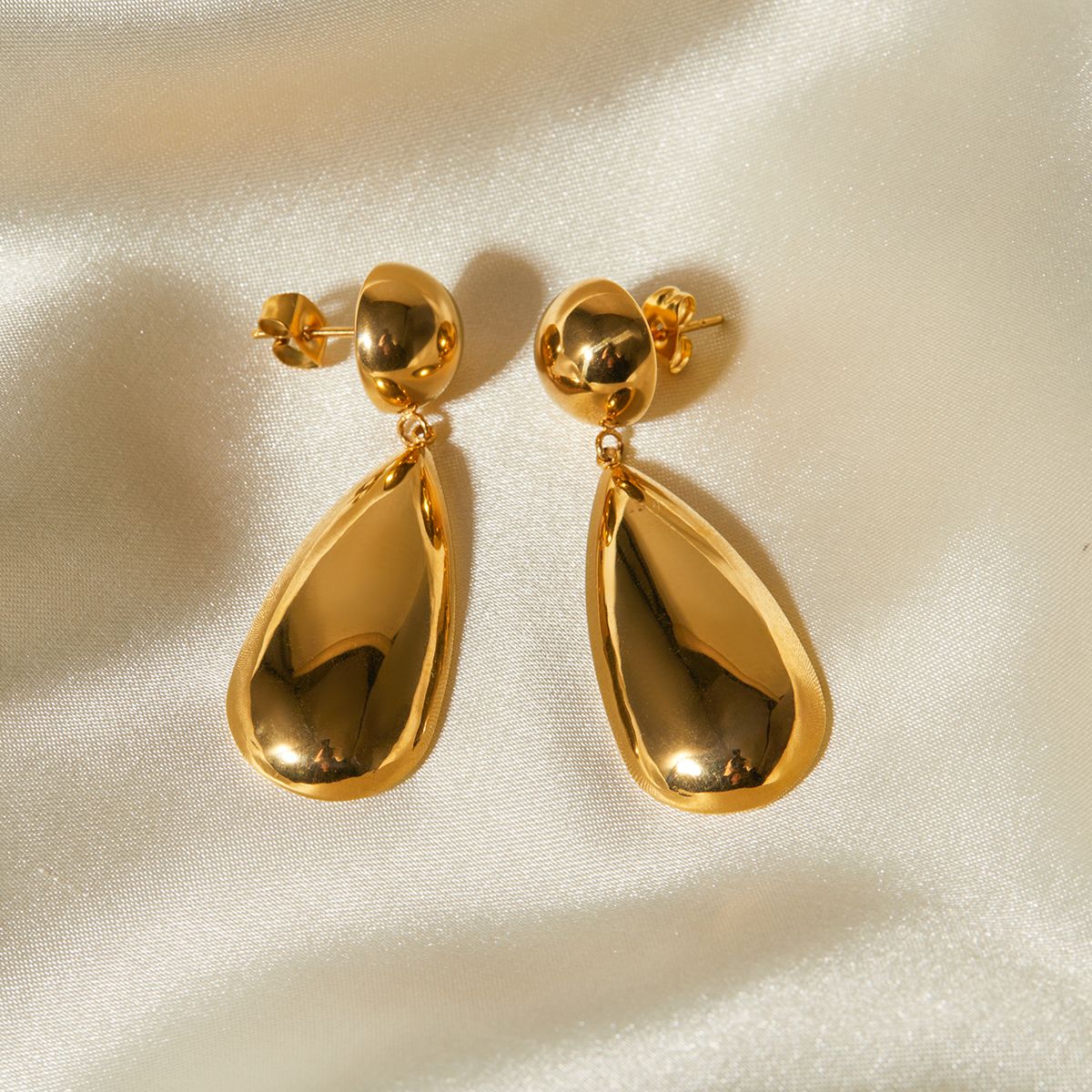 mirror-finish gold-plated teardrop earrings with smooth, fluid curves.