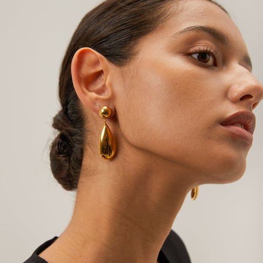 18K gold-plated teardrop earrings with sculptural, mirror-finish design, styled for elegant evening wear
