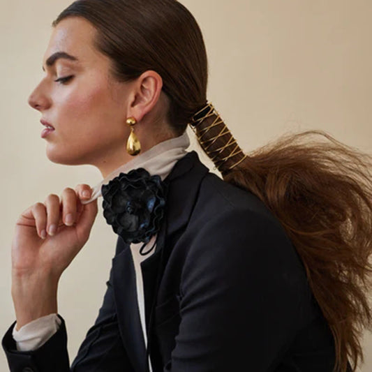 statement 18K gold-plated drop earrings reflecting light beautifully, paired with evening attire.