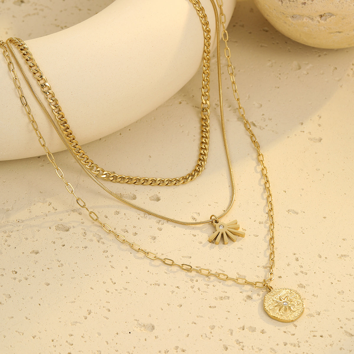 Layered sun pendant necklace in gold tone with medallion charm