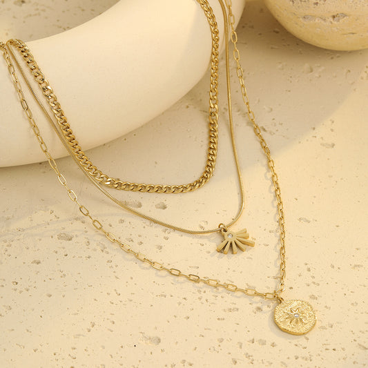 Layered sun pendant necklace in gold tone with medallion charm