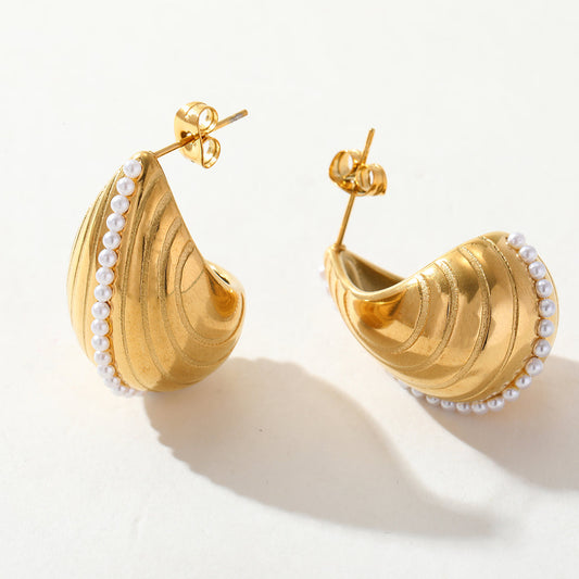 Close-up of Shell Poise earrings with seashell design and pearl accent – coastal-inspired jewellery for women