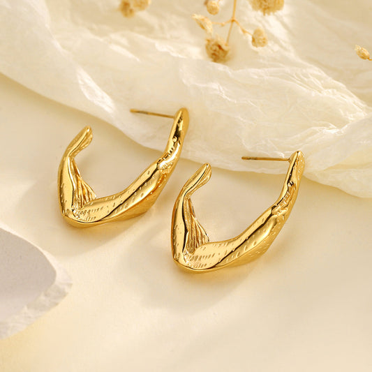 Zephyr gold sculptural hoop earrings angled view on neutral background